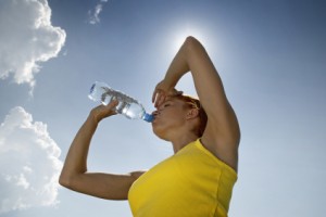 Woman drinking water in the hot sun.